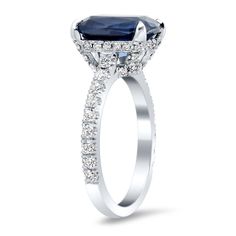 an oval cut blue sapphire and diamond halo engagement ring with side stones in 18k white gold