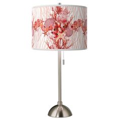 a lamp that is on top of a metal base and has a flower print shade