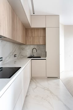 an empty kitchen with marble counter tops and white cupboards on the wall, along with wooden cabinets