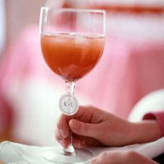 a person holding a wine glass on top of a white plate