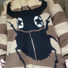 a person wearing a knitted sweater with an animal on it's chest and eyes