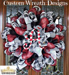 a wreath with red and white shoes on it is hanging from the front door,