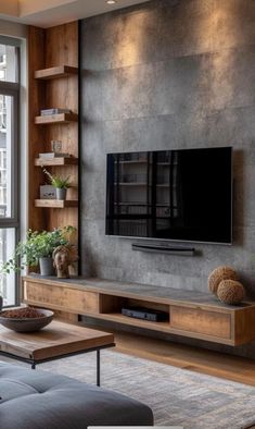 a living room with large windows and a flat screen tv mounted to the side of a wall