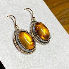 These Gorgeous Amber Earrings Are Made From Dark Antiqued Silver With Bright Gold Twisted Halos. 14k Gold Filled Ear Wires. Hallmarked .925 Sterling Silver. Genuine Baltic Amber. Matching Necklace Available. Handmade By Me And My Fellow Silversmith, Bri! Bundle And Save! Classic Yellow Oval Earrings, Classic Oval Earrings With Ear Wire, Orange Oval Jewelry With Polished Finish, Orange Oval Sterling Silver Jewelry, Oval Orange Polished Jewelry, Classic Nickel-free Oval Earrings, Brown Oval Jewelry For Anniversary, Oval Brown Jewelry For Anniversary, Classic Orange Oval Jewelry