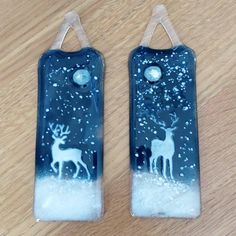 two glass bottle shaped like reindeers with snow on the bottom and one in the middle