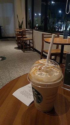 a starbucks drink sitting on top of a wooden table