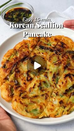 a person holding a plate with food on it and the words easy 15 min korean salmon pancake