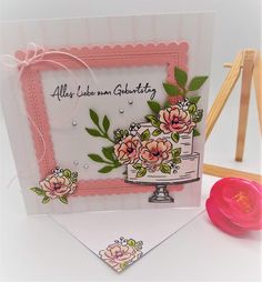 a handmade card with flowers on it, and a pink object next to it