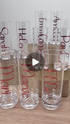 six clear glass tumblers sitting on top of a wooden table next to each other