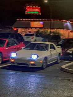 cars are parked in a parking lot at night