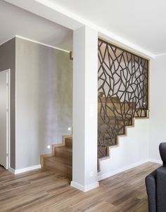 an empty living room with stairs leading up to the second floor and a painting on the wall