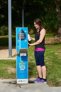 a woman standing in front of a blue and white machine with the words, we share smarts tap on it