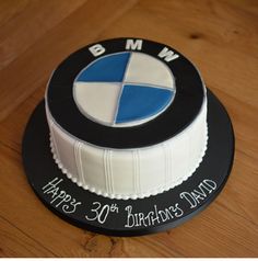 a birthday cake that is decorated with the bmw logo and happy 30th birthday dad written on it