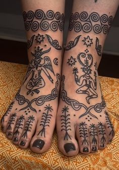 two feet with tattoos and designs on them