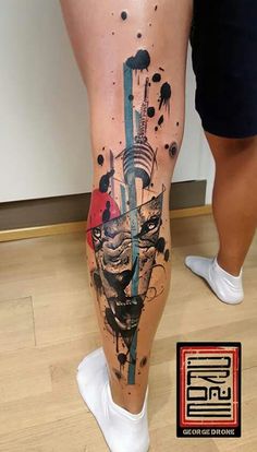 a person standing on top of a wooden floor next to a leg with an artistic tattoo