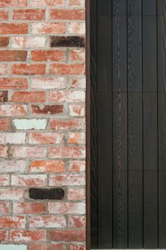 a brick wall with a wooden door next to it