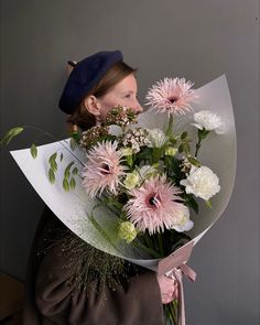 a woman is holding a bouquet of flowers