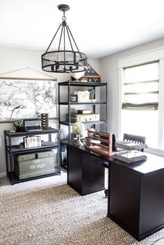 an office with two desks and a book shelf in the middle of the room