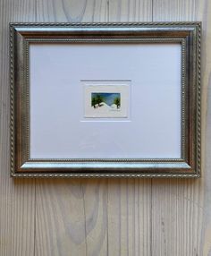 a framed photo hanging on the side of a wooden wall