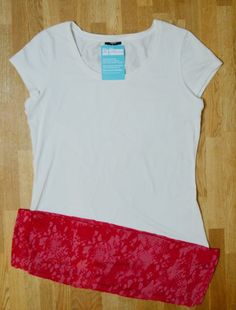 a white t - shirt with red trim is laying on the floor