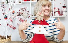 a woman is holding up a christmas decoration