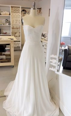 a white wedding dress on display in a room