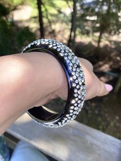 This stunning one of a kind bangle was handcrafted on black acrylic, while embellished with genuine Swarovski crystals. This glamorous cuff is lightweight, comfortable to wear, and is perfect for styling up with any look. Arrives beautifully packaged in a luxury gift box and comes included with a polishing cloth. This bangle looks even more stunning in person and sparkles so beautifully in the natural sunlight and also at night.  💎MORE DETAILS 💎 * Material: Acrylic * Stones: Swarovski crystals Red Carpet Jewelry, Bracelet Trendy, Glam Jewelry, Trendy Bracelets, Crystal Bangle, Large Jewelry, Luxury Gift Box, Black Acrylic, Black Acrylics