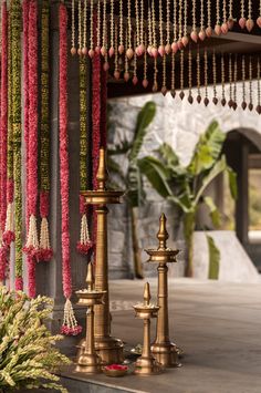 an outdoor area with candles, flowers and beads hanging from it's ceiling in front of a building