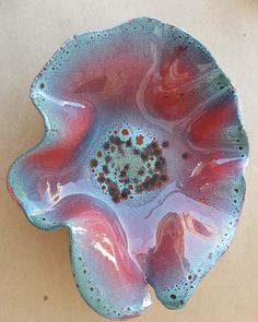 a blue and red flower shaped bowl sitting on top of a table