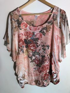 "Vintage  Lavish Plus Peach Floral Top Made in USA Scoop neckline 46% Polyester, 46% Rayon, 8% Spandex Cape/ butterfly sleeves, gathering on the side/ underarms  Size 2X Measurements taken while lying flat Neck scoop Pit to Pit 22\" Sleeves cape/butterfly Length from shoulder to bottom 26\" Purchase price includes free shipping in Canada tans the USA International shipping is available, please contact before purchase for shipping quote Any questions, just ask! Vintage item, regular wear due to age should be expected Any known flaws/markings will be listed No returns/ exchanges, but please contact if there is an issue with your item" Spring Floral Print Stretch T-shirt, Feminine Floral Print Stretch Tops, Feminine Stretch Floral Print Tops, Stretchy Peach Top For Spring, Peach Stretch Top For Spring, Fitted Floral Print Peach Tops, Fitted Peach Floral Print Tops, Tan Pants, Grey Crewneck