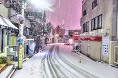 a snowy street with buildings and signs on it