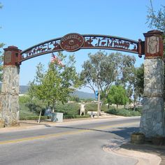 the entrance to an old town with a large iron gate and american flag flying in the background