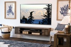 a flat screen tv mounted to the side of a wall next to a wooden table