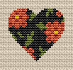 a cross stitch heart with flowers on it