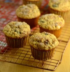 three muffins sitting on top of a wooden cutting board