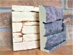 a stack of rocks sitting on top of a wooden floor next to a brick wall