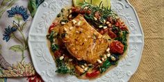 a white plate topped with fish and vegetables