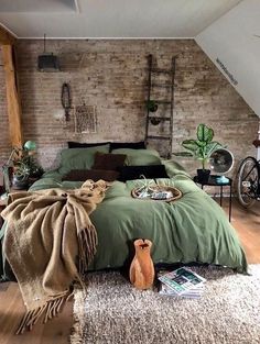 a bedroom with exposed brick walls and green bedding, rugs on the floor