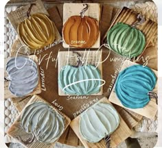 several different colored pumpkins sitting on top of each other in front of a wooden box