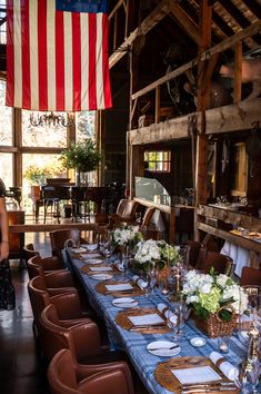 a long table is set up with place settings for an american flag themed dinner party