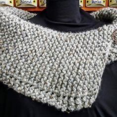 a mannequin wearing a gray knitted scarf with buttons on it's collar