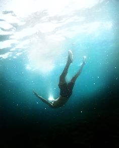 a person is swimming in the water with their feet above the water's surface