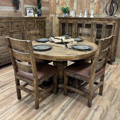 a wooden table with four chairs and plates on it in a room that has wood flooring