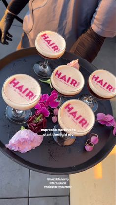 there are four desserts on the table with hair written on them, and flowers