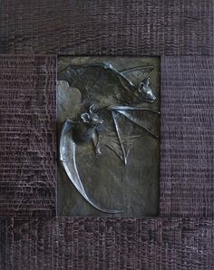 a metal plaque with a bat on it