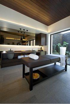 a spa room with a large window overlooking the pool and outdoor area that is well lit