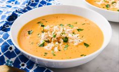 two white bowls filled with soup on top of a table