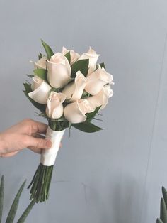 a person holding a bouquet of white roses