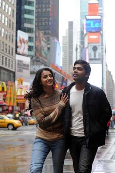 a man and woman walking down the street in new york city on a rainy day