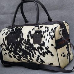 This stylish black and white hair on cowhide duffel bag is perfect for business trips, weekend getaways, or day-to-day use. - Free shipping on all cowhide duffle purse. - The size of this cowhide duffle purse is 20" x 12" x 12" - Inside pocket. - Safety Lock Zip. - Perfect to carry it on shoulders or by the handle. - You will receive the cowhide bag similar to shown in the picture. - It takes approx seven to ten business days to finish each cowhide bag. This luxurious, masculine-styled leather d Western Bags, Mens Weekend Bag, Black Glamour, Cowgirl Accessories, Faux Cowhide, Overnight Travel Bag, Leather Duffel Bag, Leather Duffel, Cowhide Bag